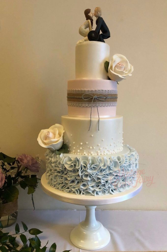 four tier wedding cake with ruffles and statement sugar roses